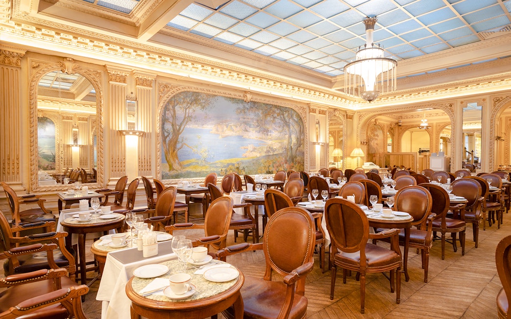 Elegant dining room of Angelina Rivoli with mural, Paris, France.