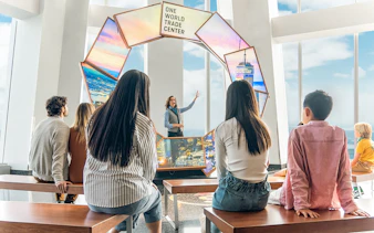 Tourists engaging with City Pulse display at One World Observatory, New York City.