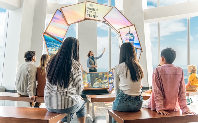 Tourists engaging with City Pulse display at One World Observatory, New York City.