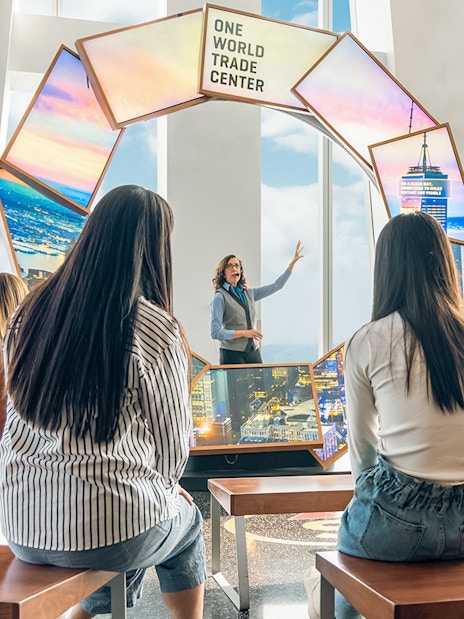 Tourists engaging with City Pulse display at One World Observatory, New York City.