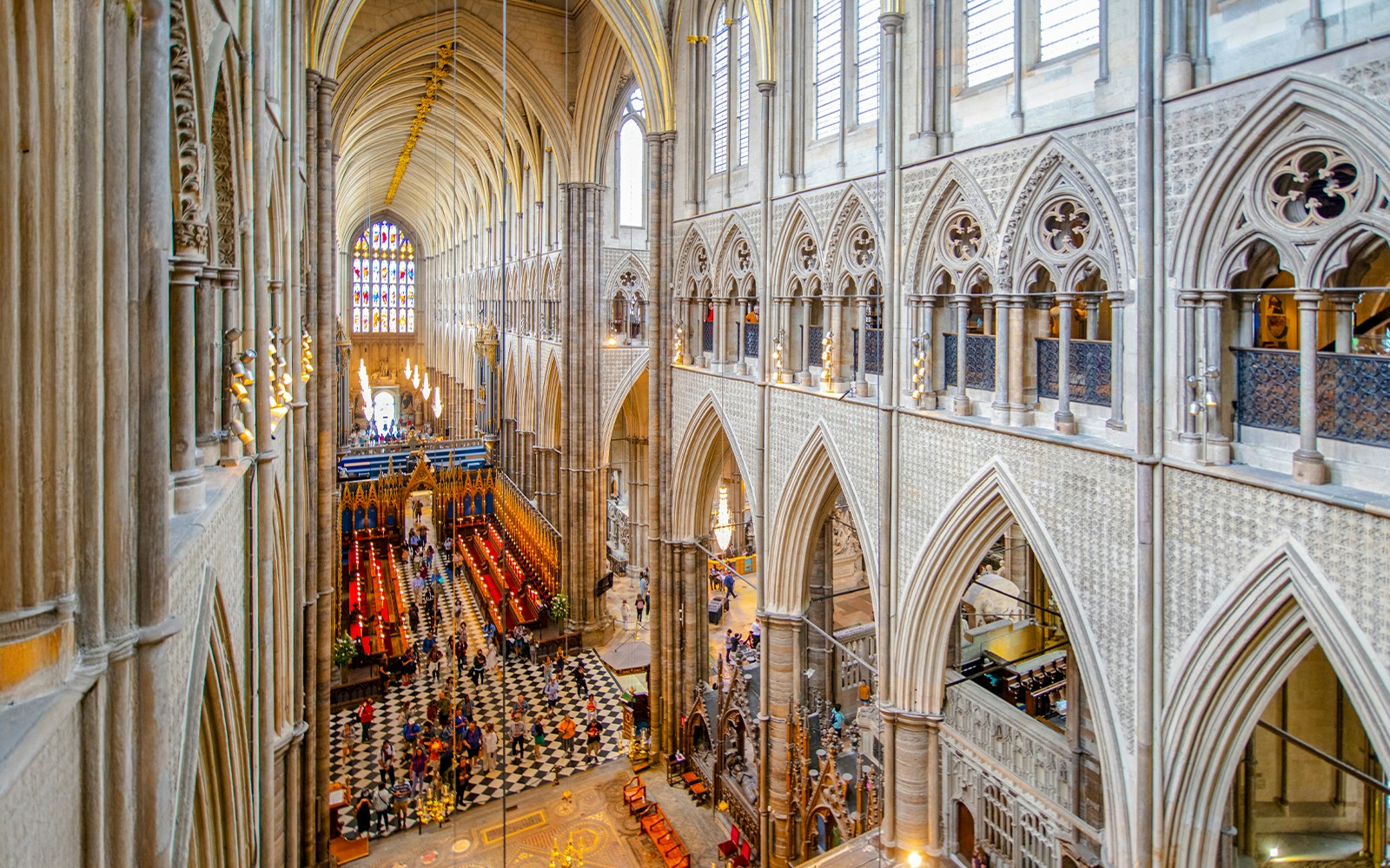 Nave of Westminster Abbey showcasing Gothic architecture and stained glass windows.