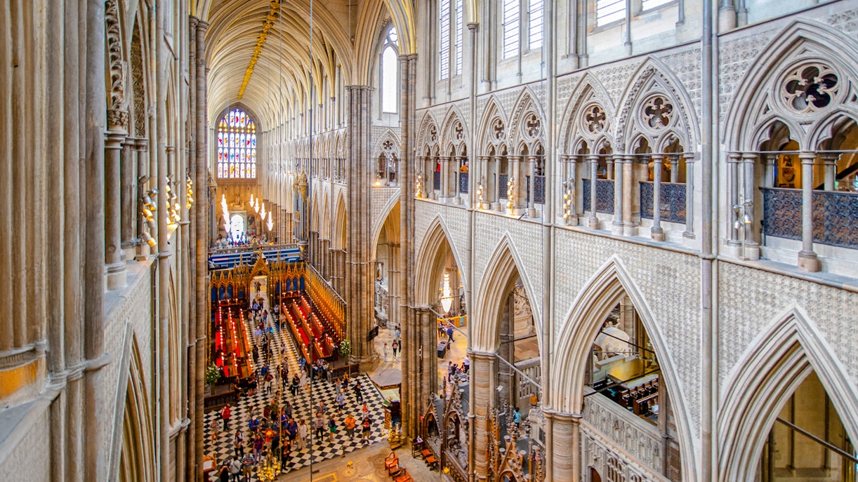 Nave of Westminster Abbey showcasing Gothic architecture and stained glass windows.
