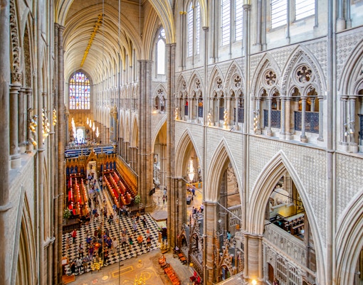 Nave of Westminster Abbey showcasing Gothic architecture and stained glass windows.