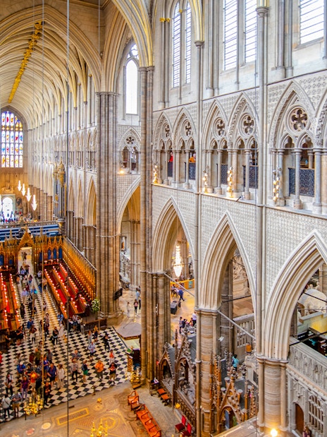 Nave of Westminster Abbey showcasing Gothic architecture and stained glass windows.