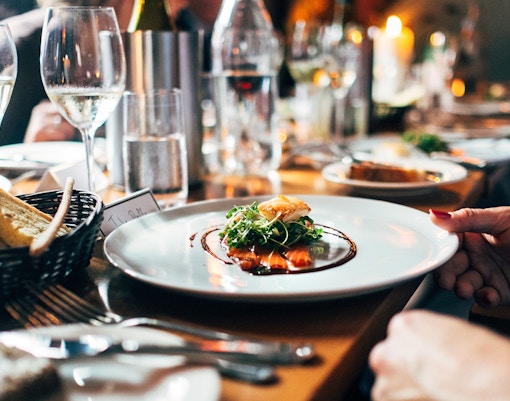 Fine dining experience with gourmet dish and wine glasses.