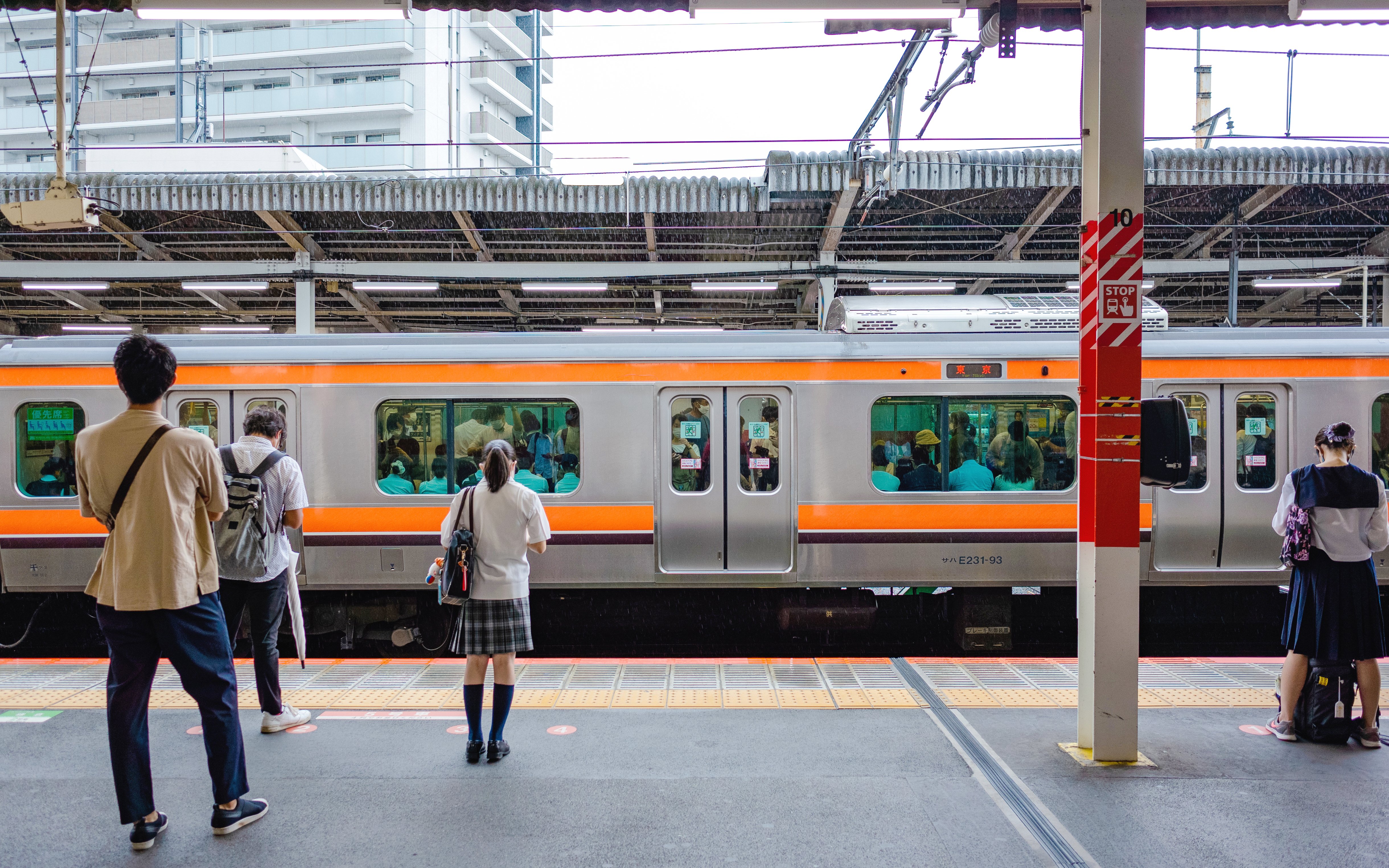 People waiting on a platform for a train at a Japanese station.