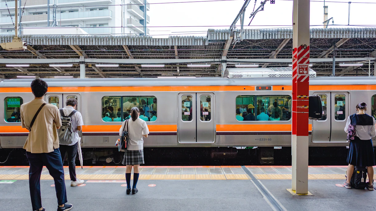 People waiting on a platform for a train at a Japanese station.