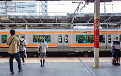 People waiting on a platform for a train at a Japanese station.