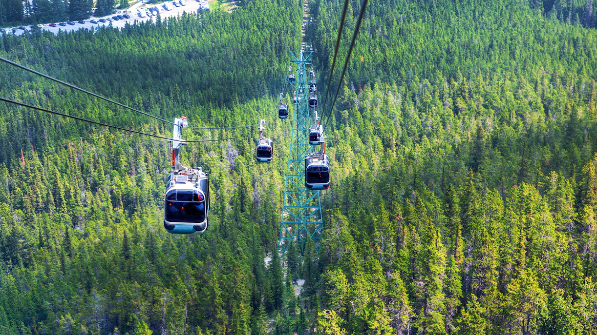 Gondola ride over forested landscape at Sulphur Mountain in Banff National Park.
