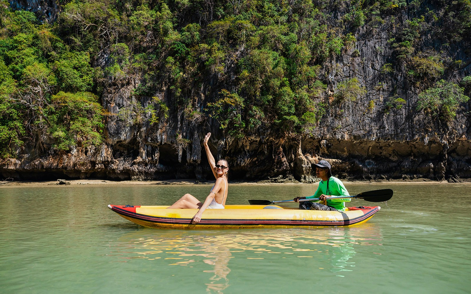 Canoeing at Hong Island with a local paddler, limestone cliffs in the background.