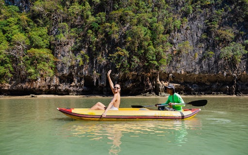 Canoeing at Hong Island with a local paddler, limestone cliffs in the background.