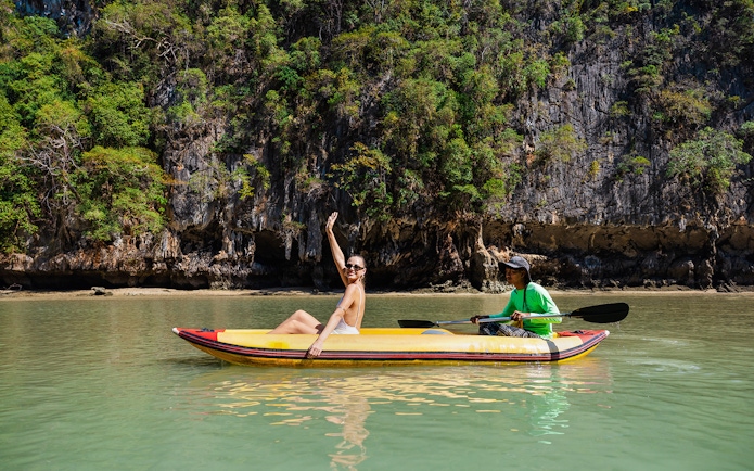 Canoeing at Hong Island with a local paddler, limestone cliffs in the background.
