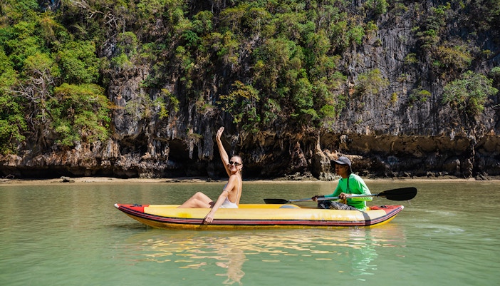 Canoeing at Hong Island with a local paddler, limestone cliffs in the background.