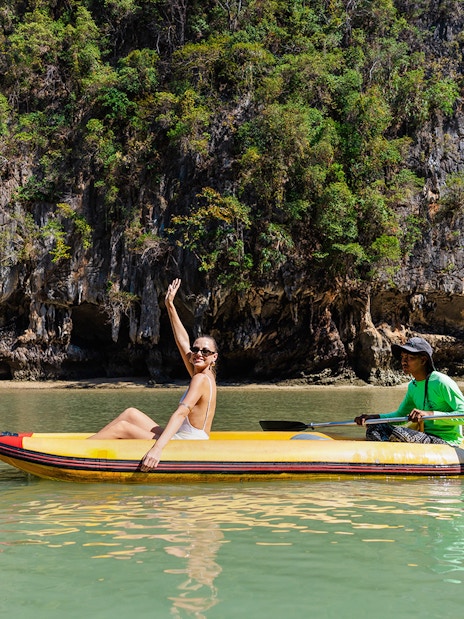 Canoeing at Hong Island with a local paddler, limestone cliffs in the background.