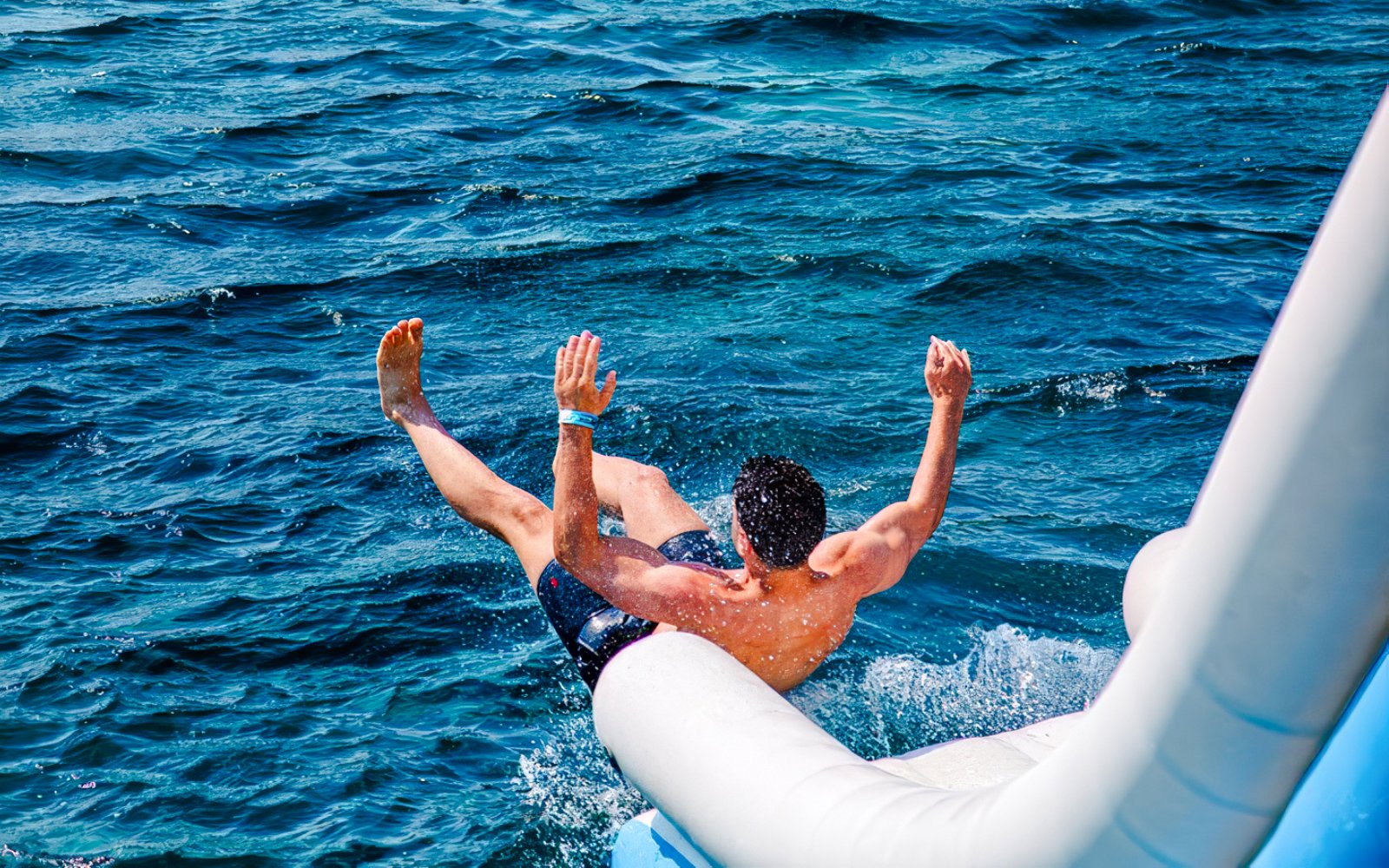 Guest sliding into the sea during Blue Lagoon and 3 Island tour from Split.