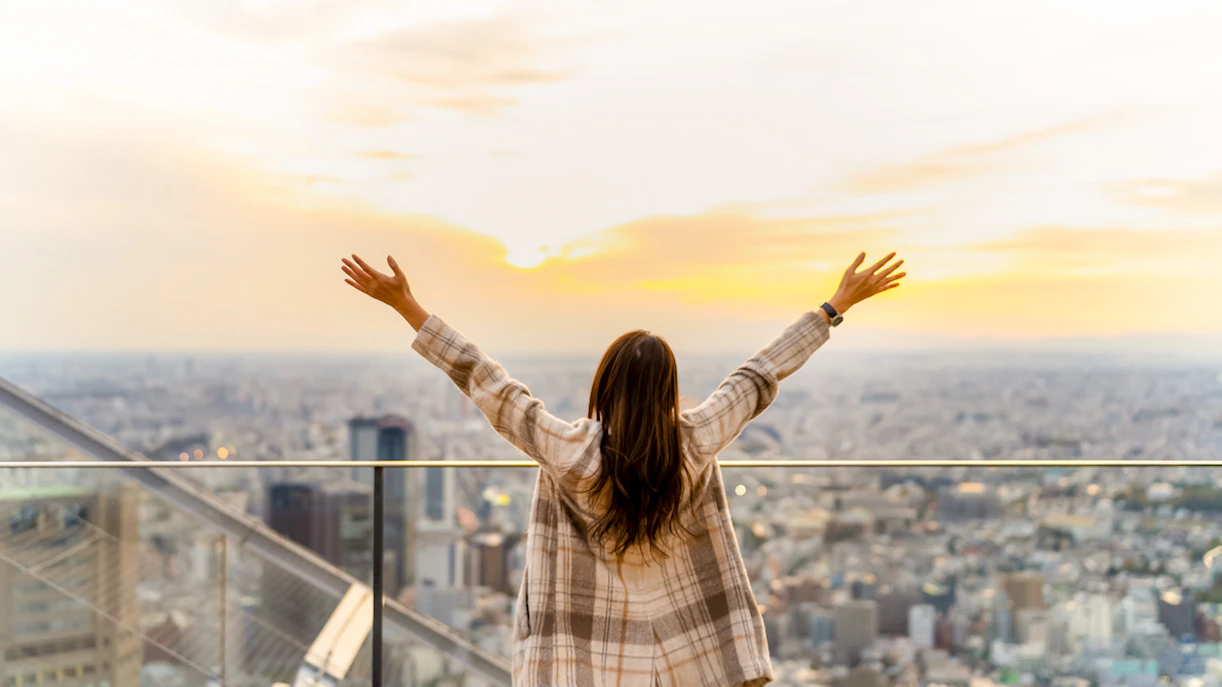 Tourist enjoying sunset view from Shibuya Sky Deck in Tokyo.