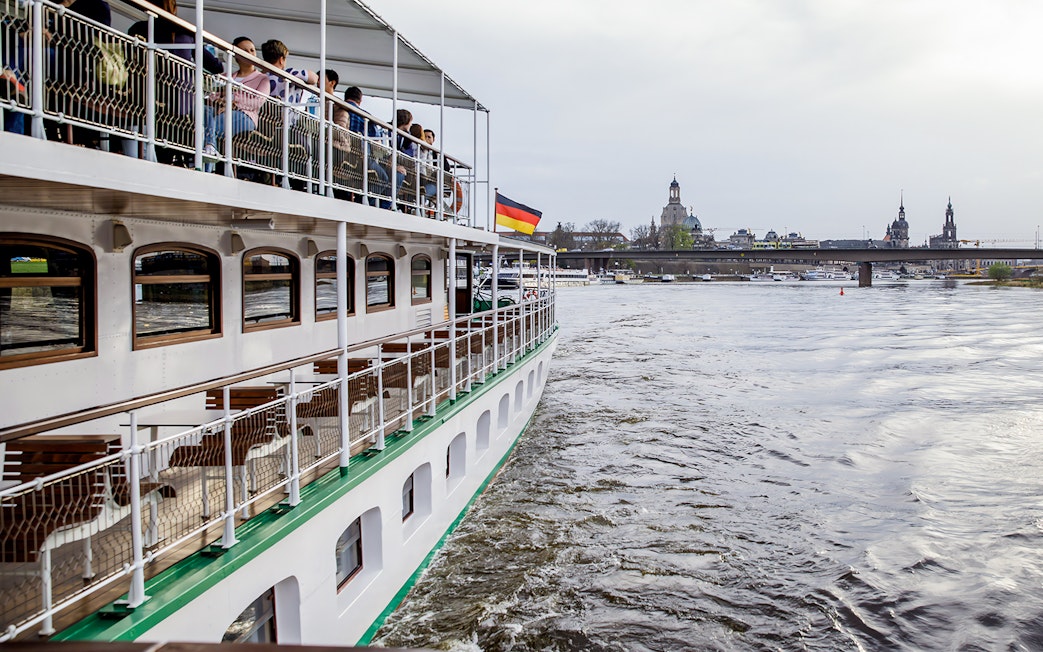 Cruise ship on Elbe River with Dresden skyline in background.