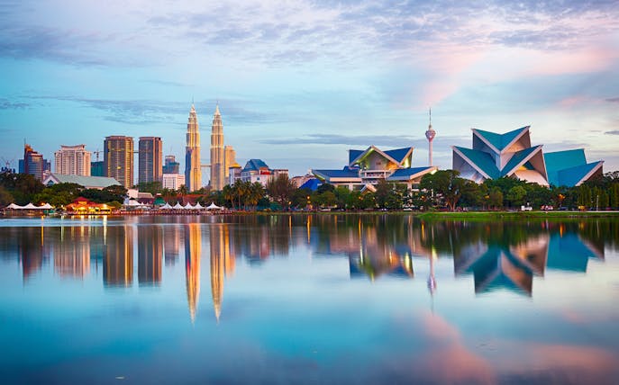 Kuala Lumpur skyline with Petronas Towers and lake reflection, Malaysia.