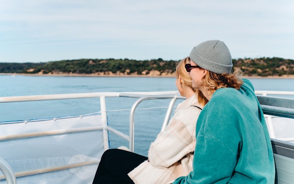Couple enjoying Cape Woolamai coastline view from Phillip Island morning cruise.