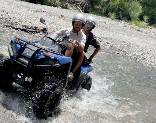 Quad bikes traversing rocky terrain at Alcantara Gorges, Sicily, during a guided tour.
