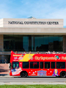 Red double-decker bus in front of the National Constitution Center, Philadelphia Hop-On-Hop-Off Tour.