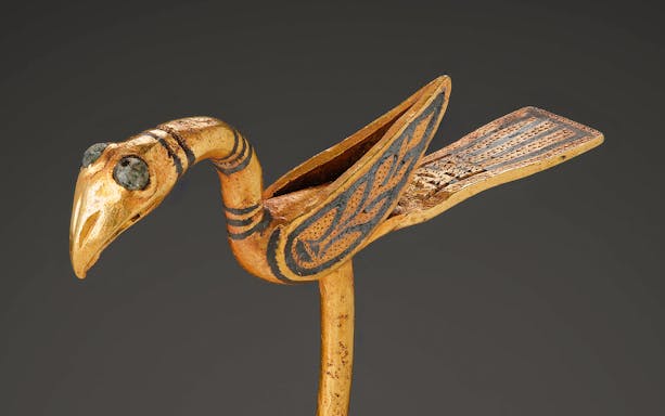 Viking Age bird-shaped pin with intricate carvings and gemstone eyes.