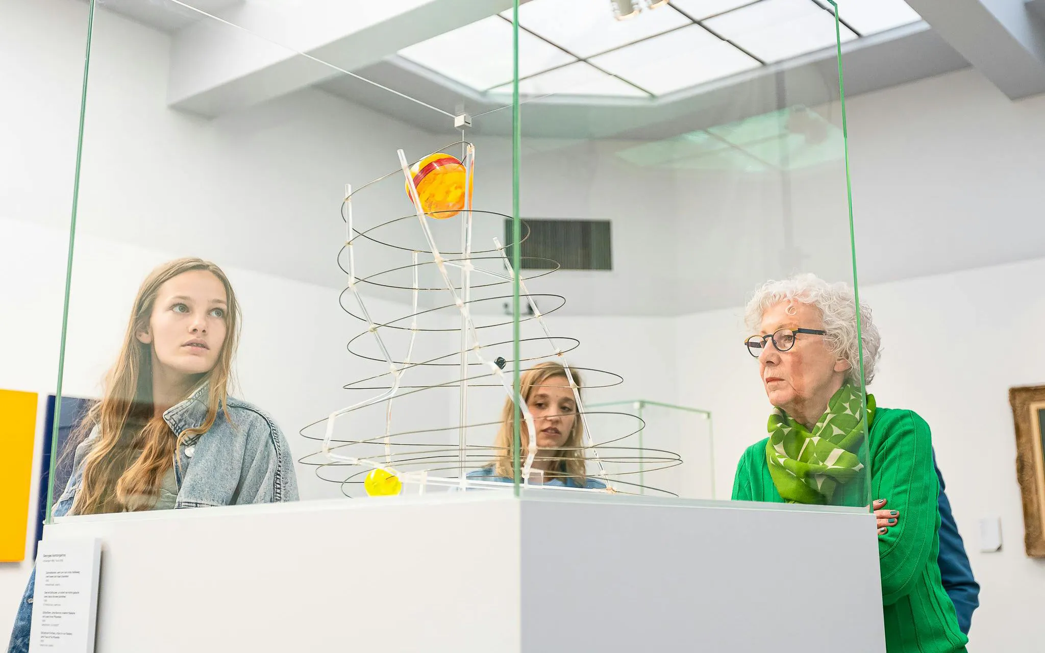 Visitors observing modern art sculpture at Groeningemuseum, Bruges.
