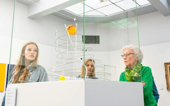 Visitors observing modern art sculpture at Groeningemuseum, Bruges.