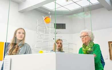 Visitors observing modern art sculpture at Groeningemuseum, Bruges.