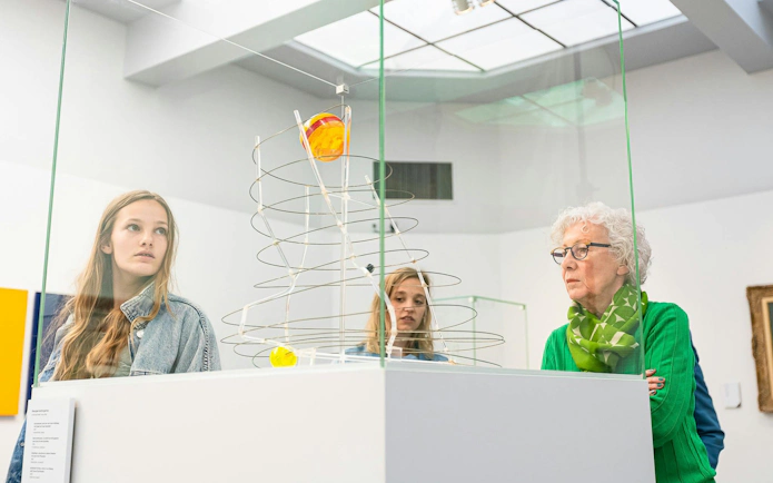 Visitors observing modern art sculpture at Groeningemuseum, Bruges.