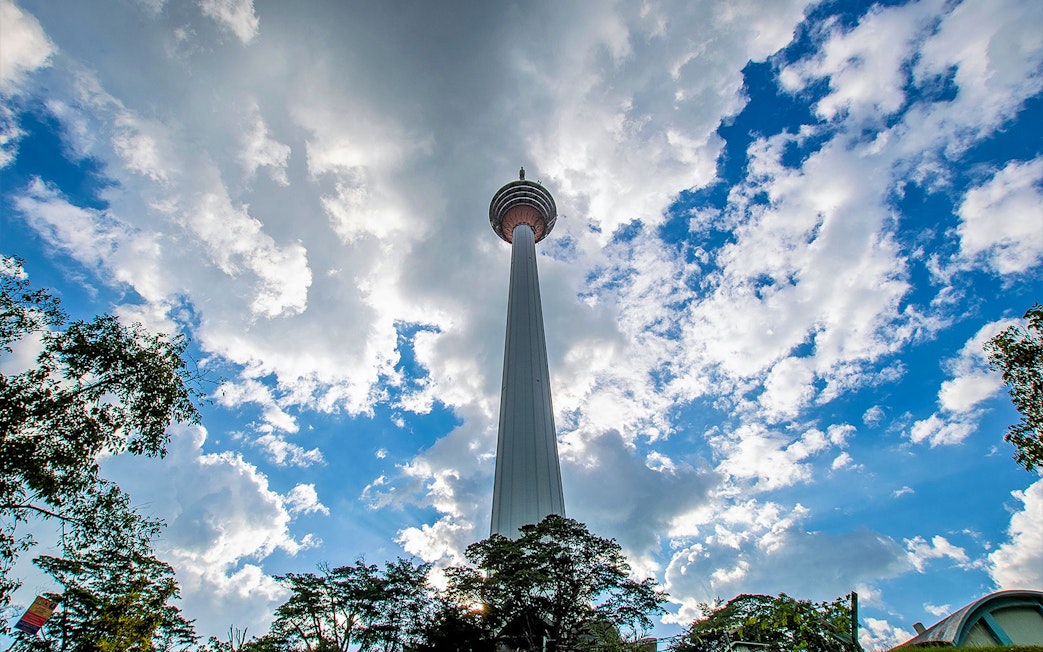 Kuala Lumpur Tower against a cloudy sky on the Putrajaya & Batu Caves Private Tour.