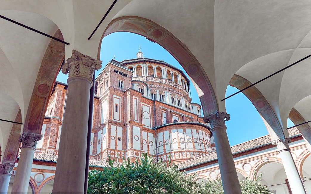 Santa Maria delle Grazie exterior, Milan, Italy, viewed through arches on a guided tour of Da Vinci's Last Supper.
