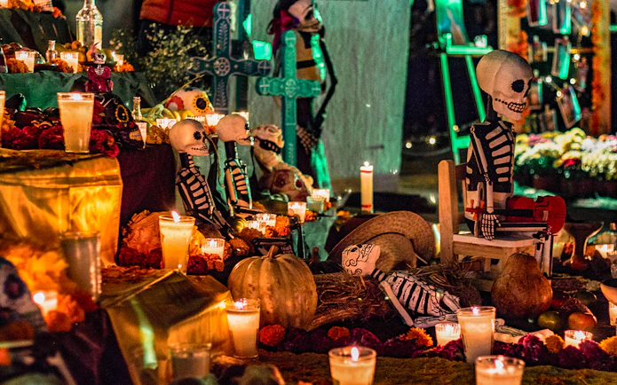 Day of the Dead altar with candles, marigolds, and skeleton figures in Mexico.