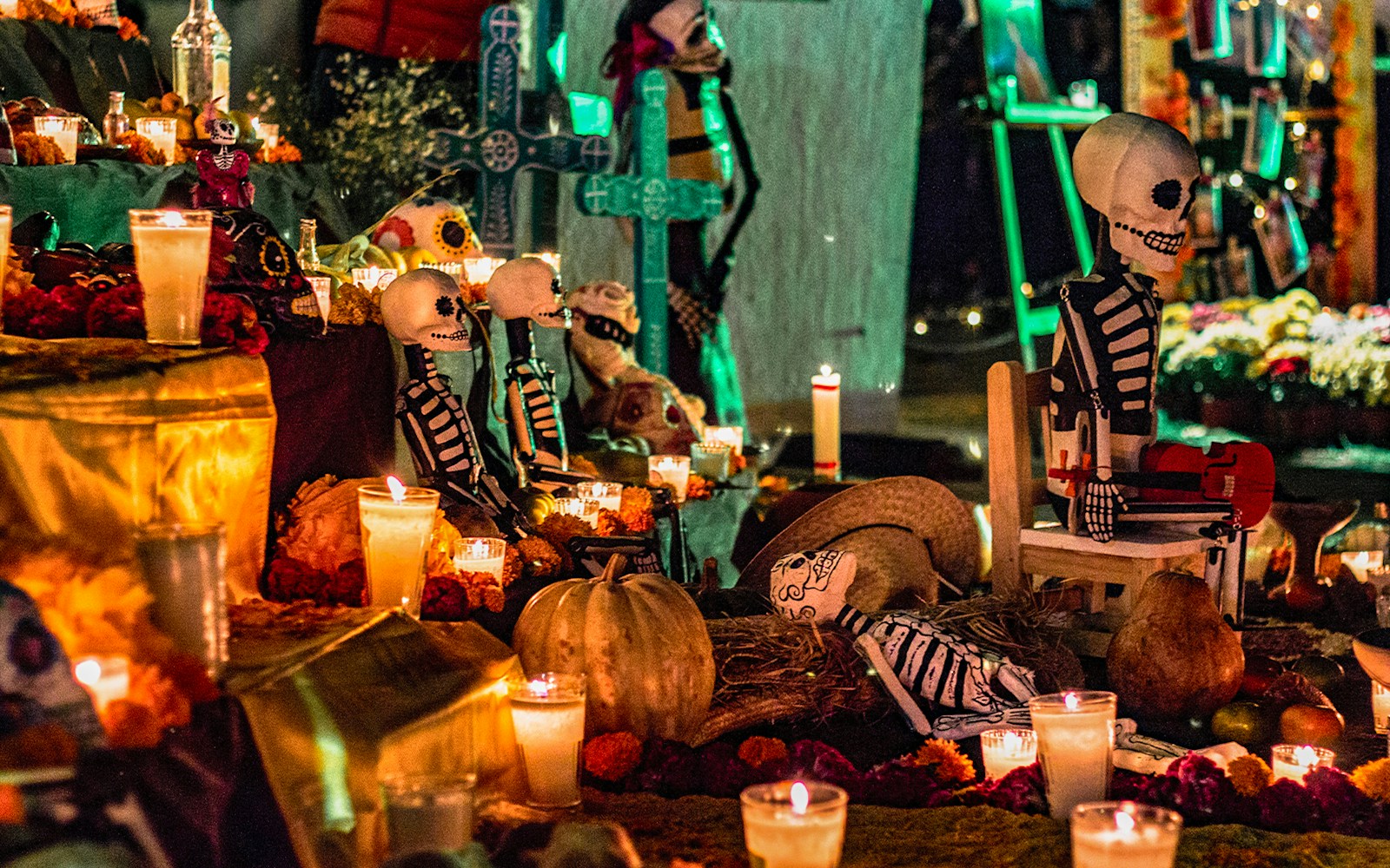 Day of the Dead altar with candles, marigolds, and skeleton figures in Mexico.