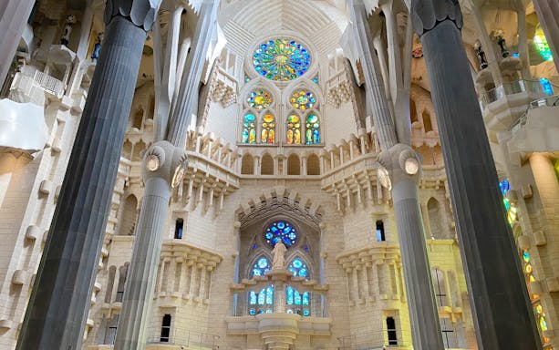 Interior view of Sagrada Familia with stained glass windows and columns, Barcelona.