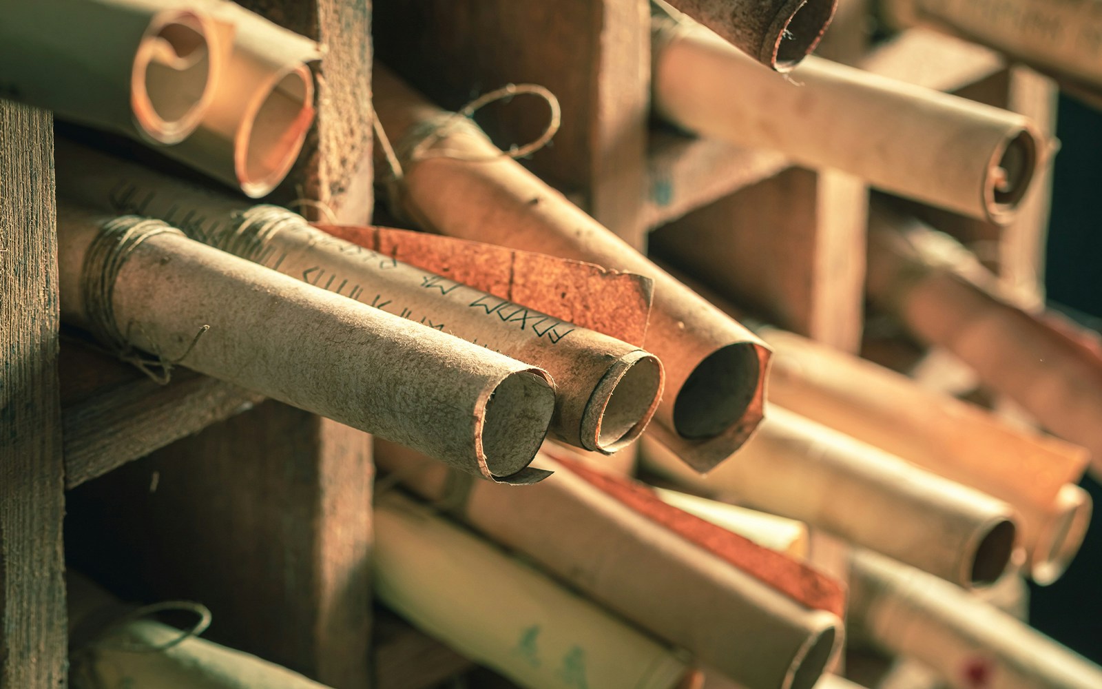 Medieval scrolls stored in a wooden shelf in an ancient library.