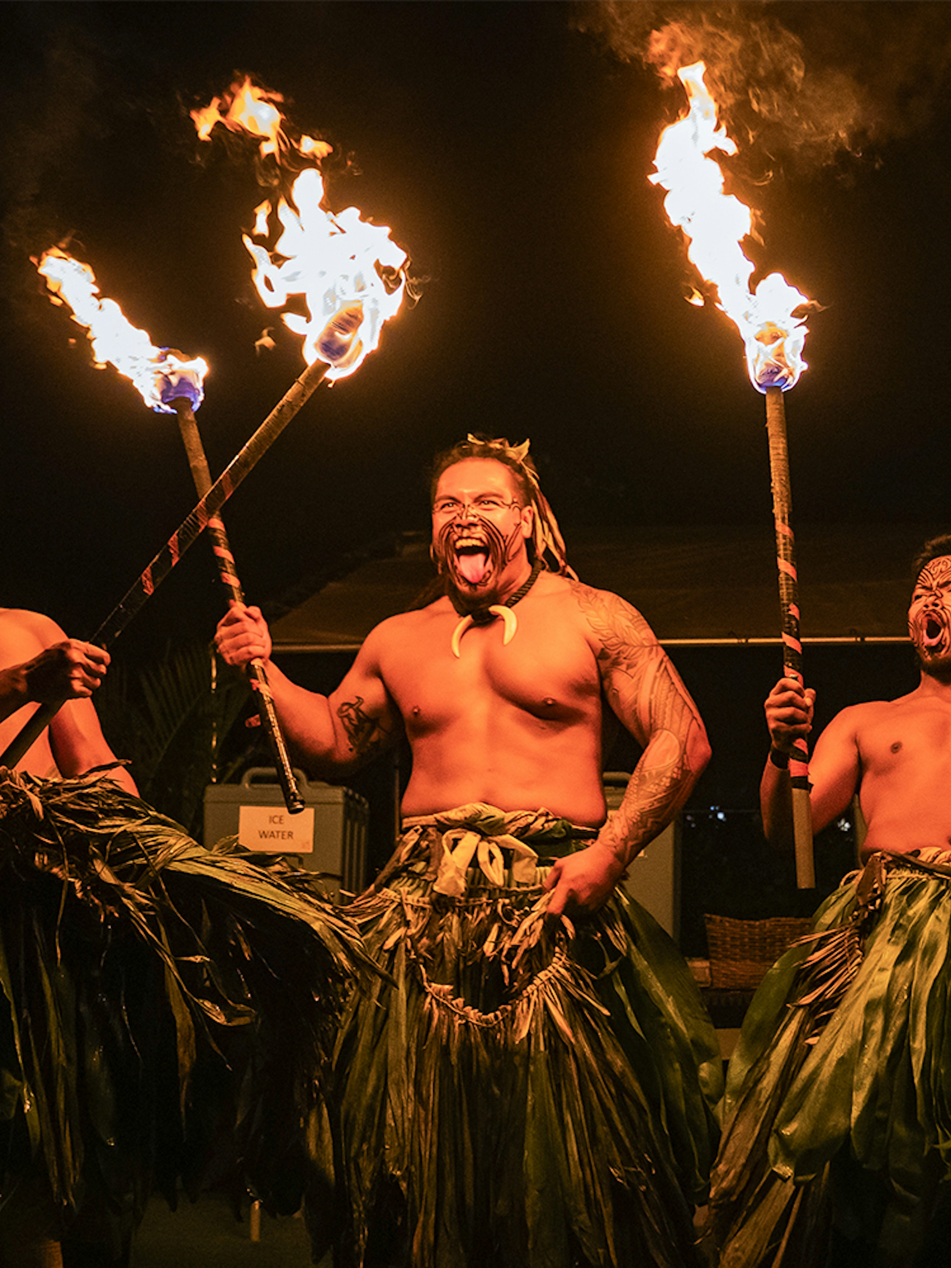 Fire dancers performing with torches on stage at Mauka Luau.