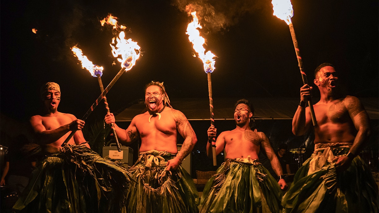Fire dancers performing with torches on stage at Mauka Luau.
