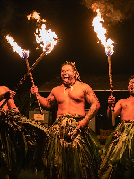 Fire dancers performing with torches on stage at Mauka Luau.