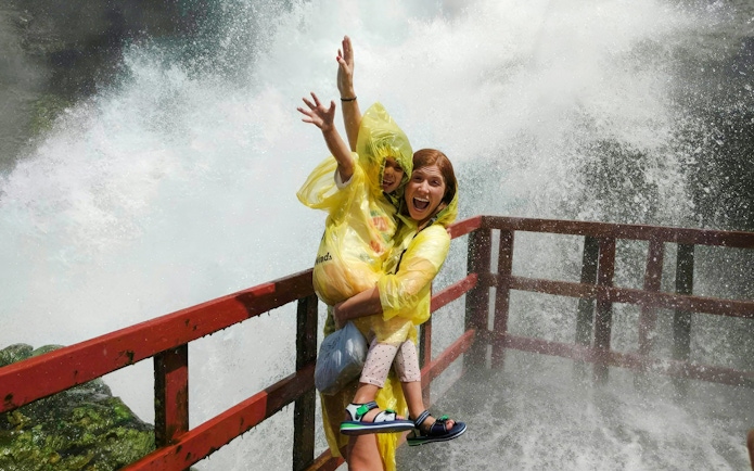 Guests in yellow ponchos enjoying the mist at Cave of the Winds, Niagara Falls.