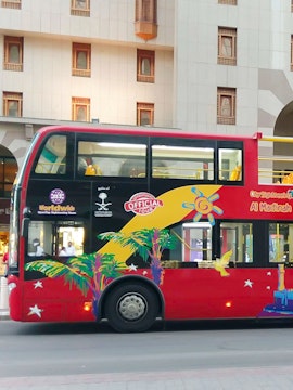 City Sightseeing Medina double-decker bus parked near a building.