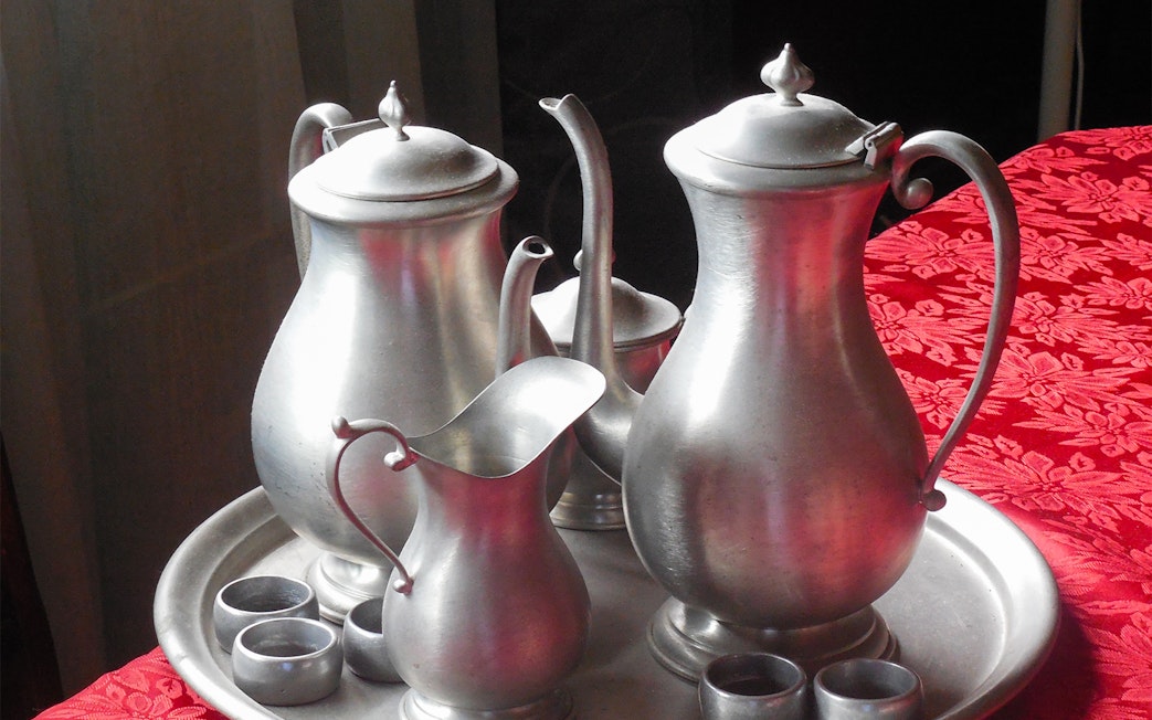 Silver tea set on a red tablecloth, part of a cultural experience on the Batu Caves tour from Kuala Lumpur.