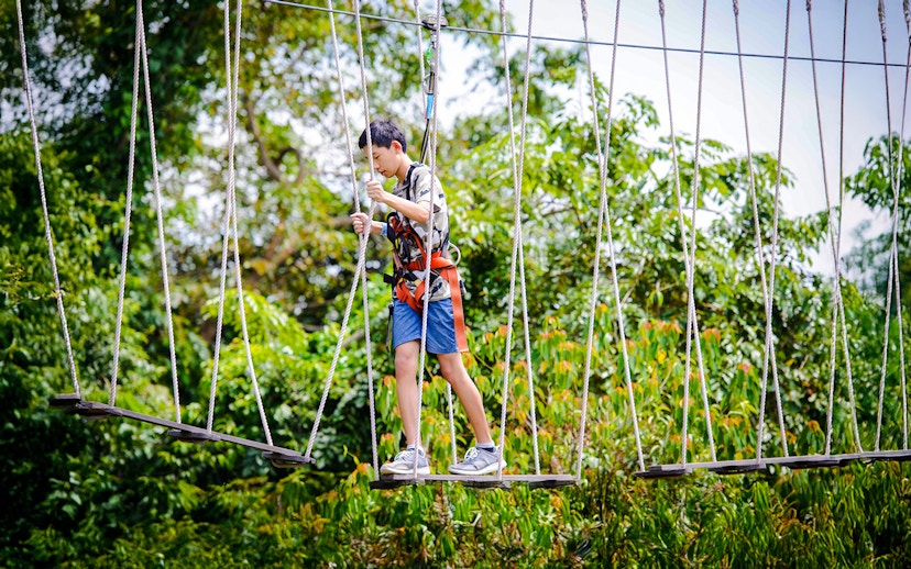 Participant crossing rope bridge at Mega Adventure Park Singapore.