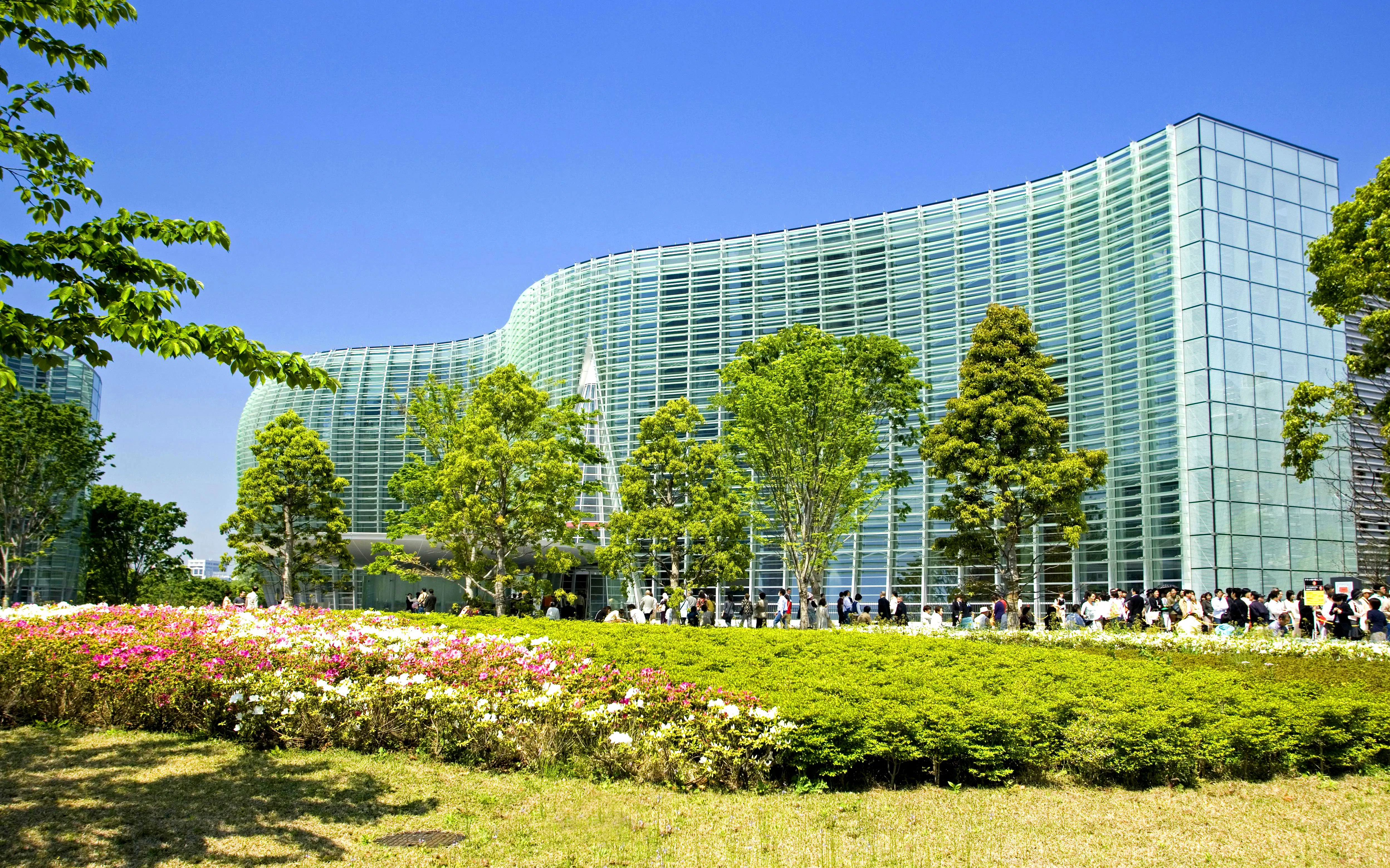 National Art Center Tokyo with lush greenery and visitors outside.