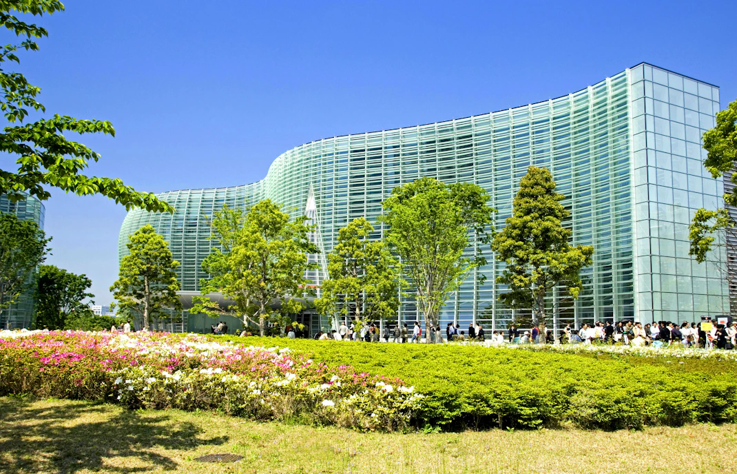 National Art Center Tokyo with lush greenery and visitors outside.