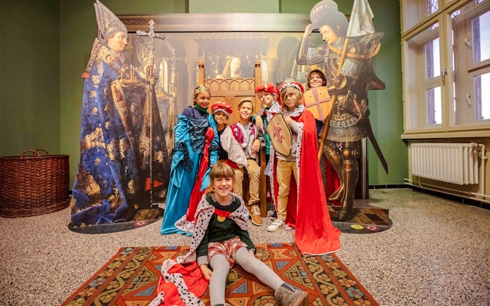 Guests in medieval costumes at Historium Bruges exhibit.