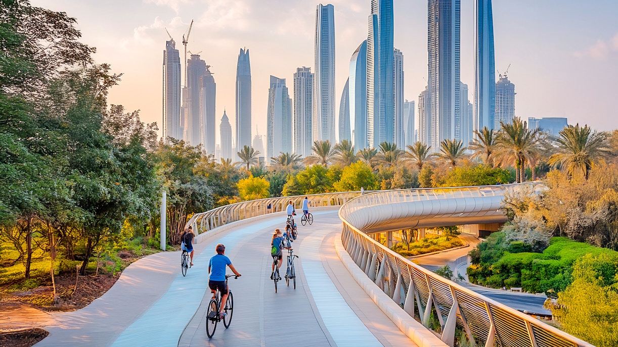 Cyclists on a winding track with Dubai skyline in the background.