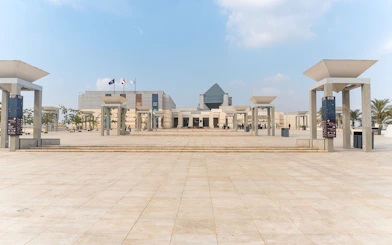 Entrance of the Museum of Civilization in Cairo with flags and modern architecture.