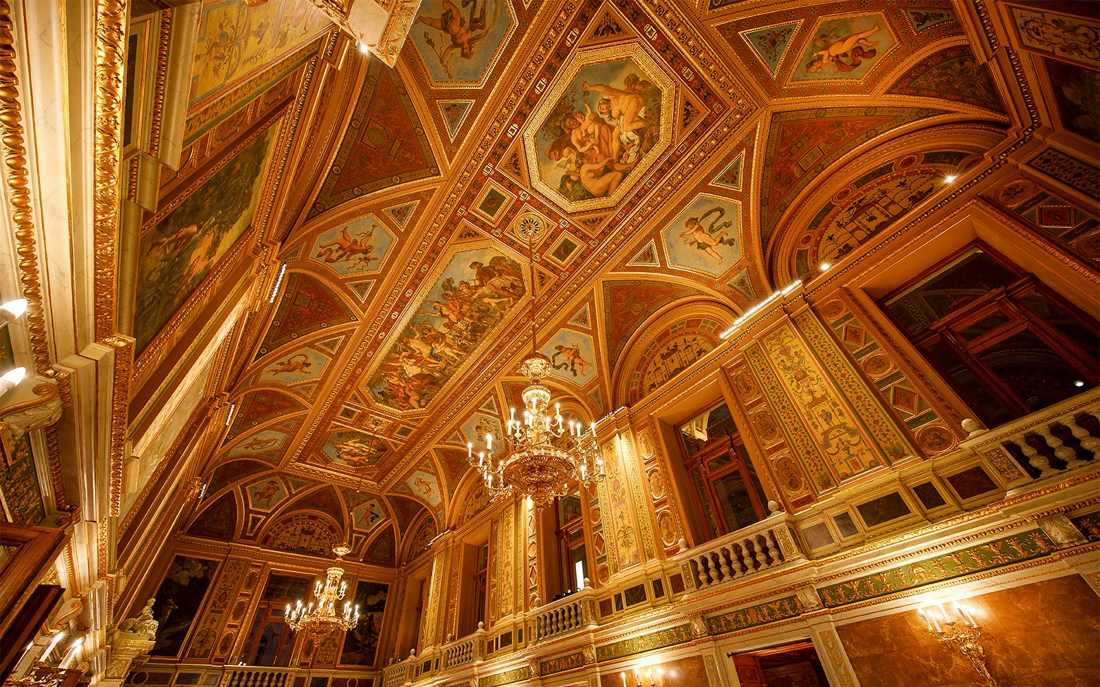 Wide angle view of ornate ceiling and chandeliers in the Hungarian State Opera, Budapest.