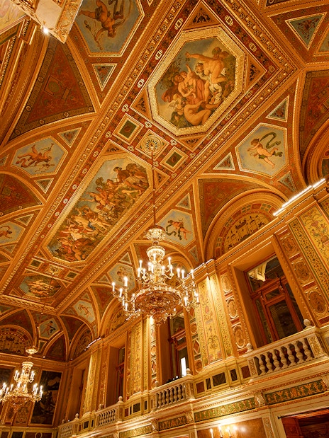 Wide angle view of ornate ceiling and chandeliers in the Hungarian State Opera, Budapest.